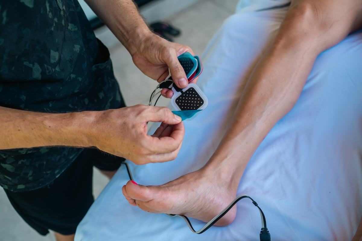 Electro-muscle stimulation pads attached to leg for lymphatic drainage therapy