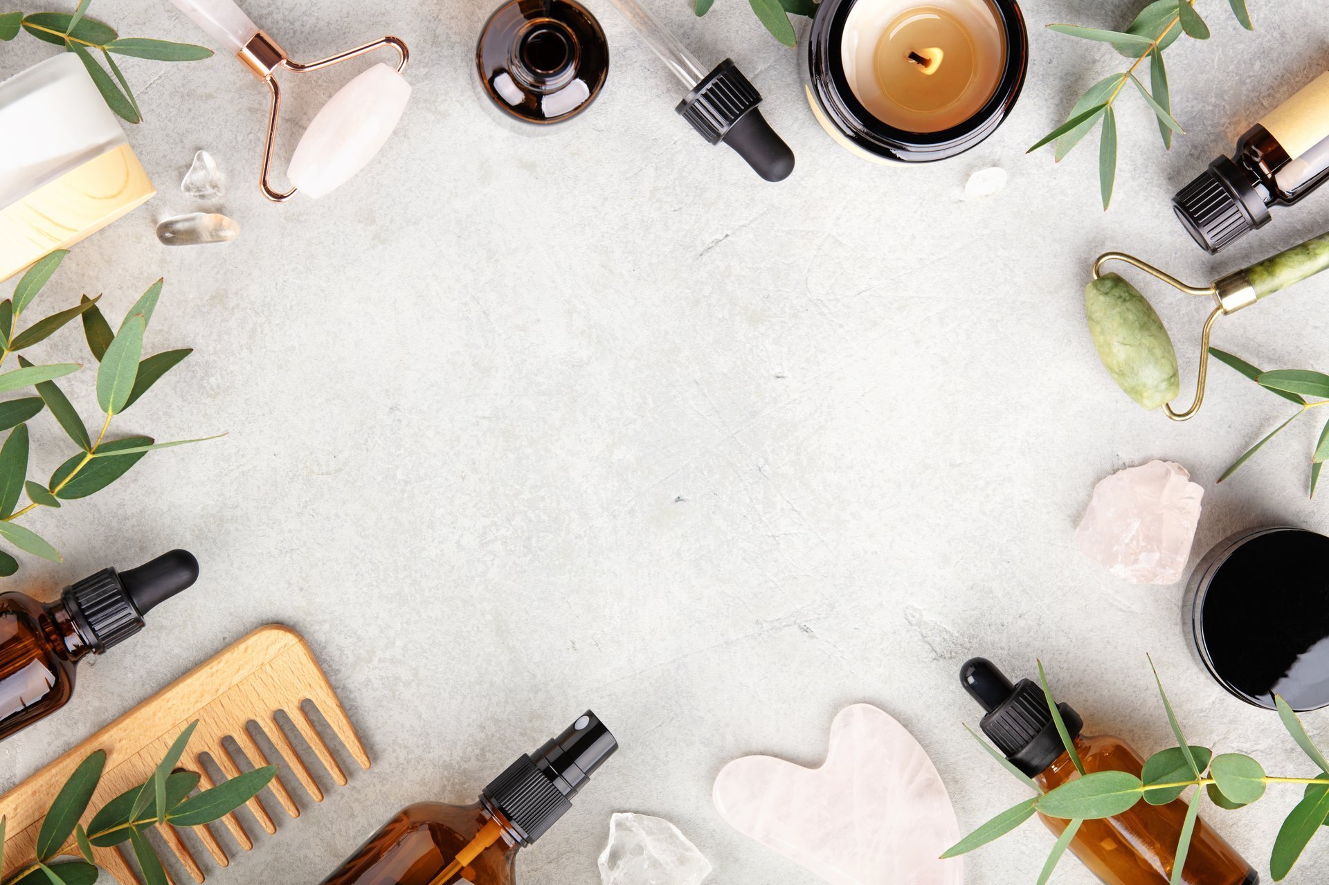 Elegant spa flat lay with eucalyptus, jade rollers, candles, and crystals