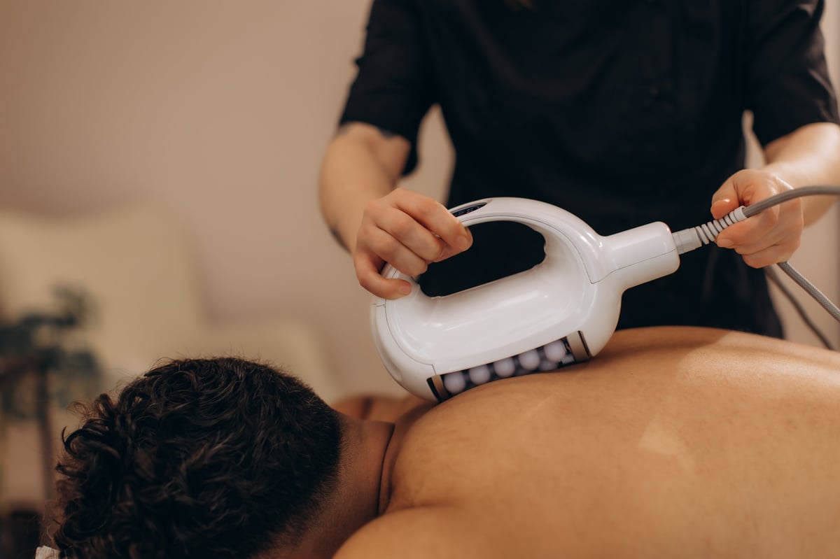 Body contouring massage treatment with modern Microvibration Therapy device for feminine sculpting